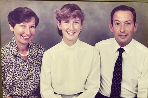 A family portrait of Joy and her husband with their daughter.
